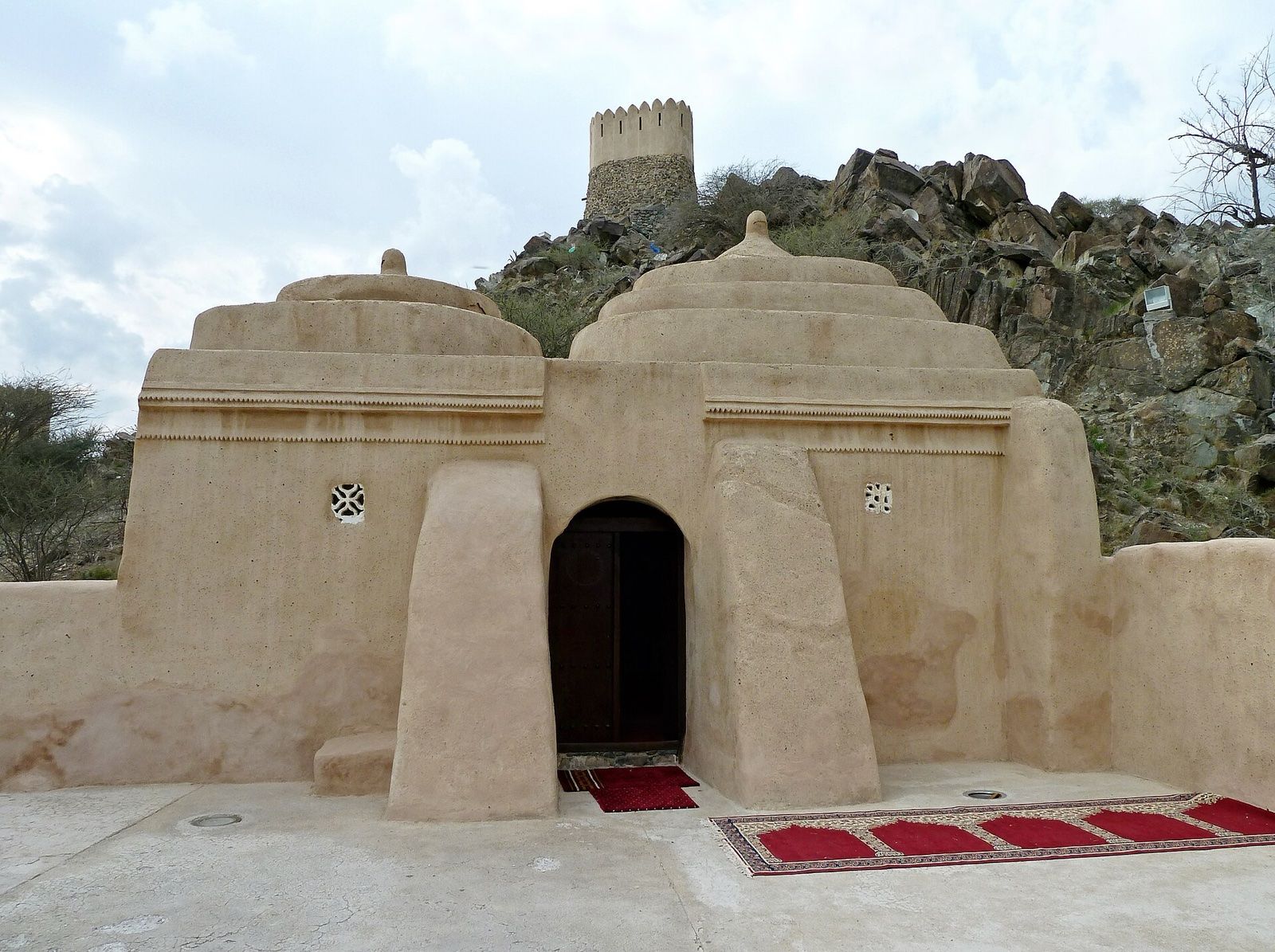 Al Badiyah Mosque, a historic mud-brick mosque in Fujairah, below a hilltop watchtower