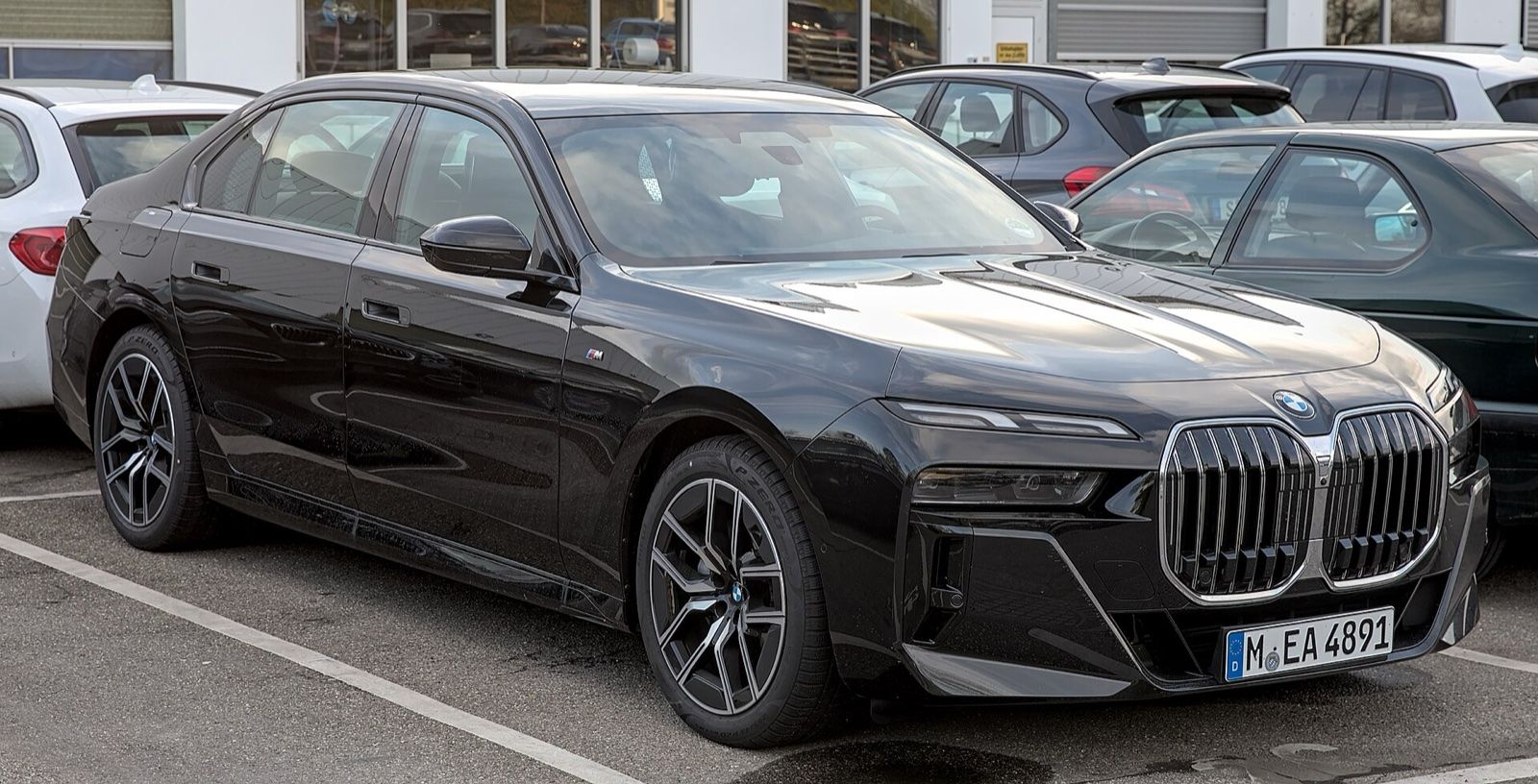 Black BMW 7 Series (G70) sedan, front three-quarter view in a car park
