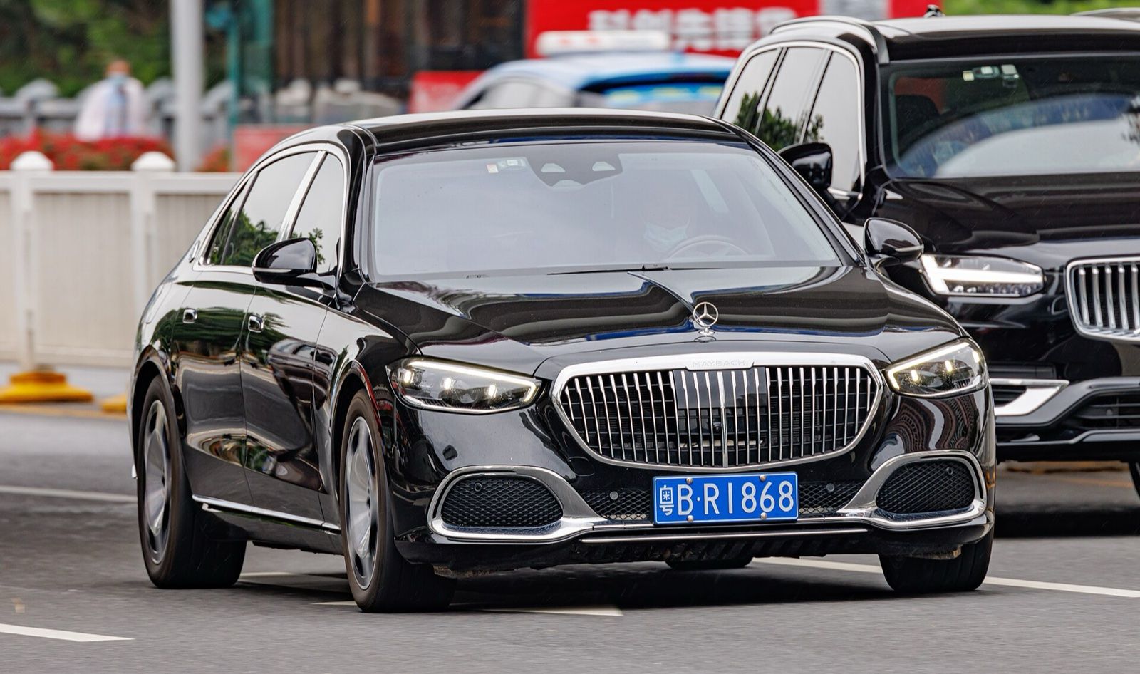 Black Mercedes-Maybach S-Class limousine driving on a city road