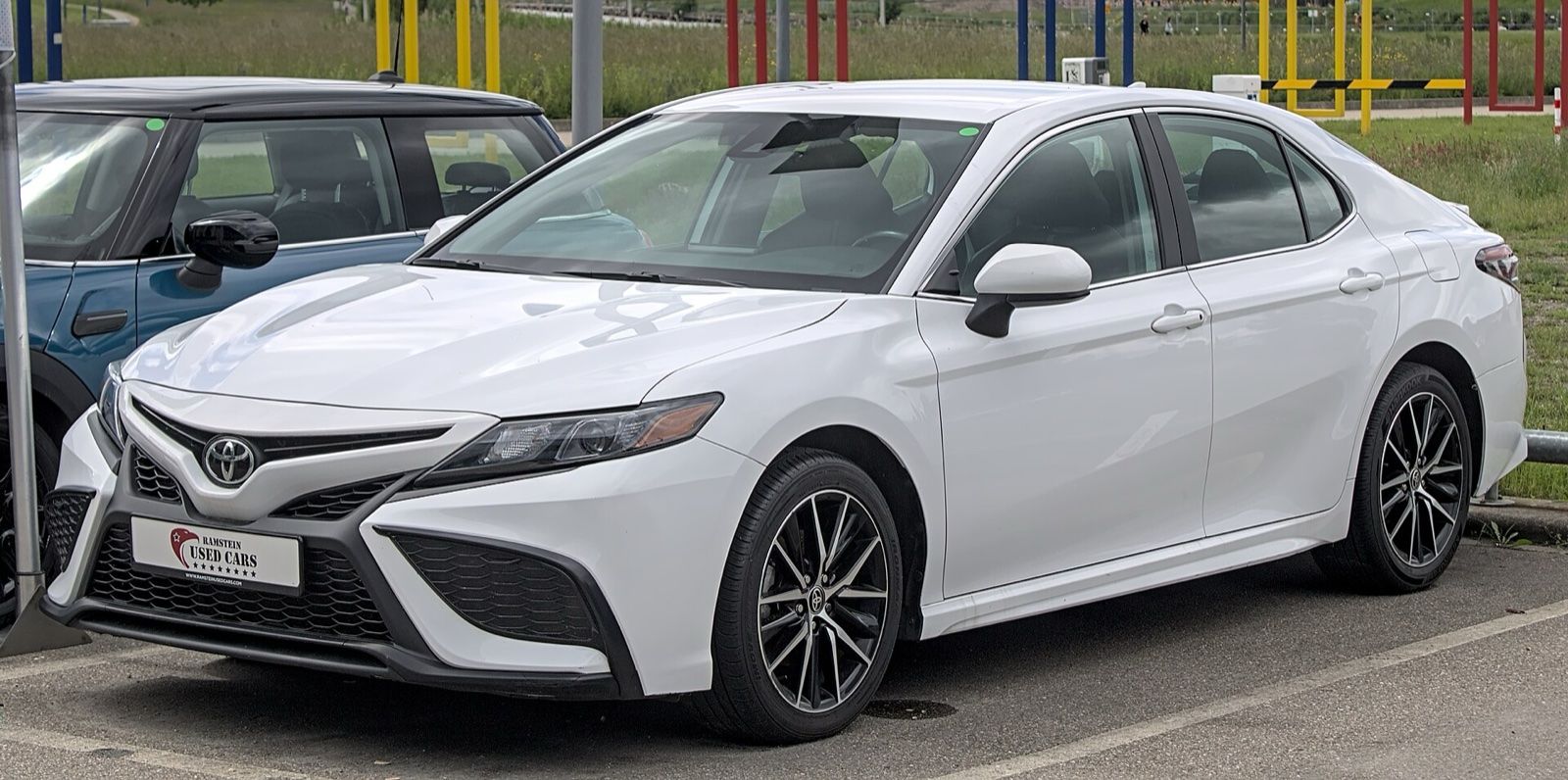 White Toyota Camry sedan, front three-quarter view, parked outdoors