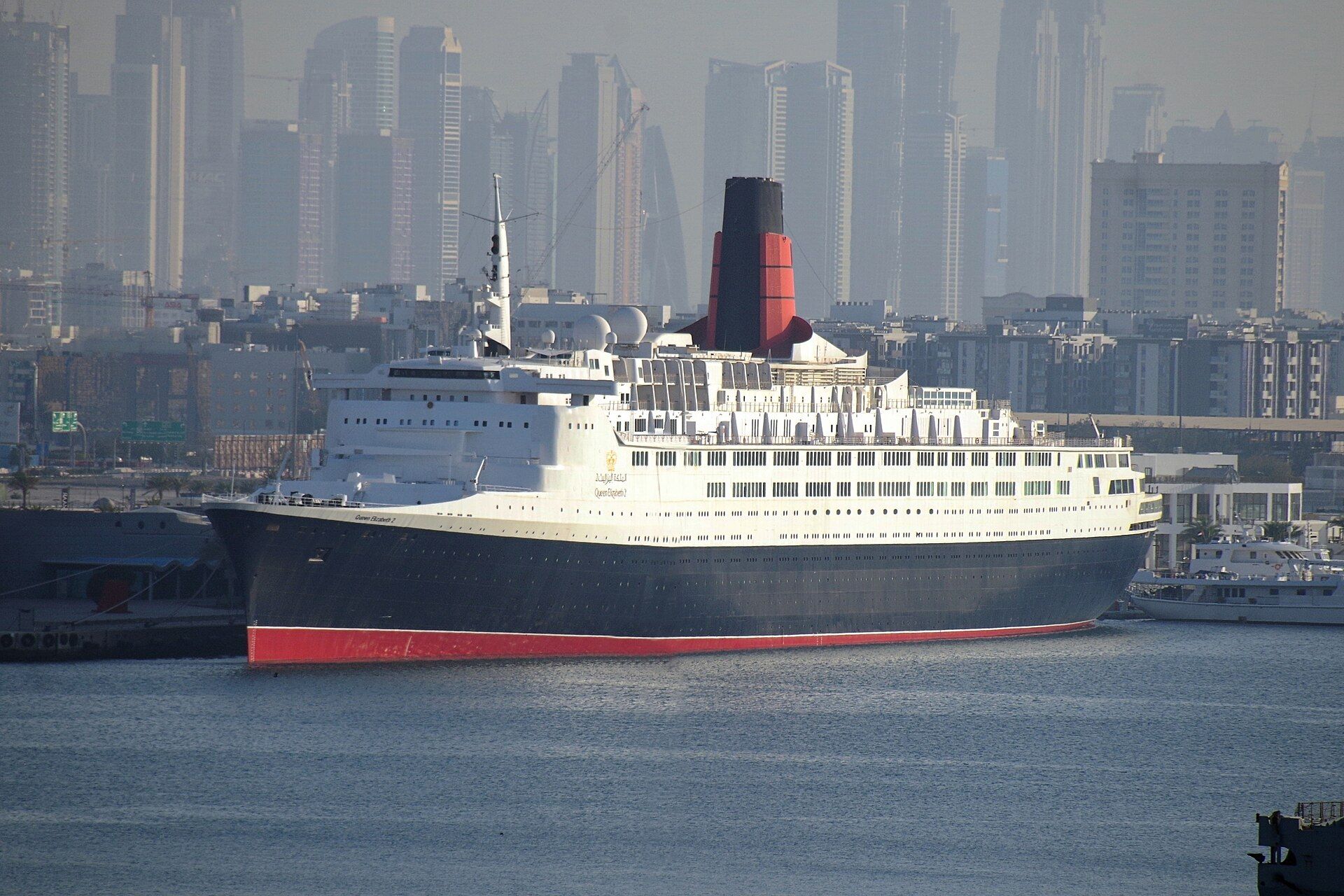 Queen Elizabeth 2 ocean liner moored at Port Rashid in Dubai with city towers behind